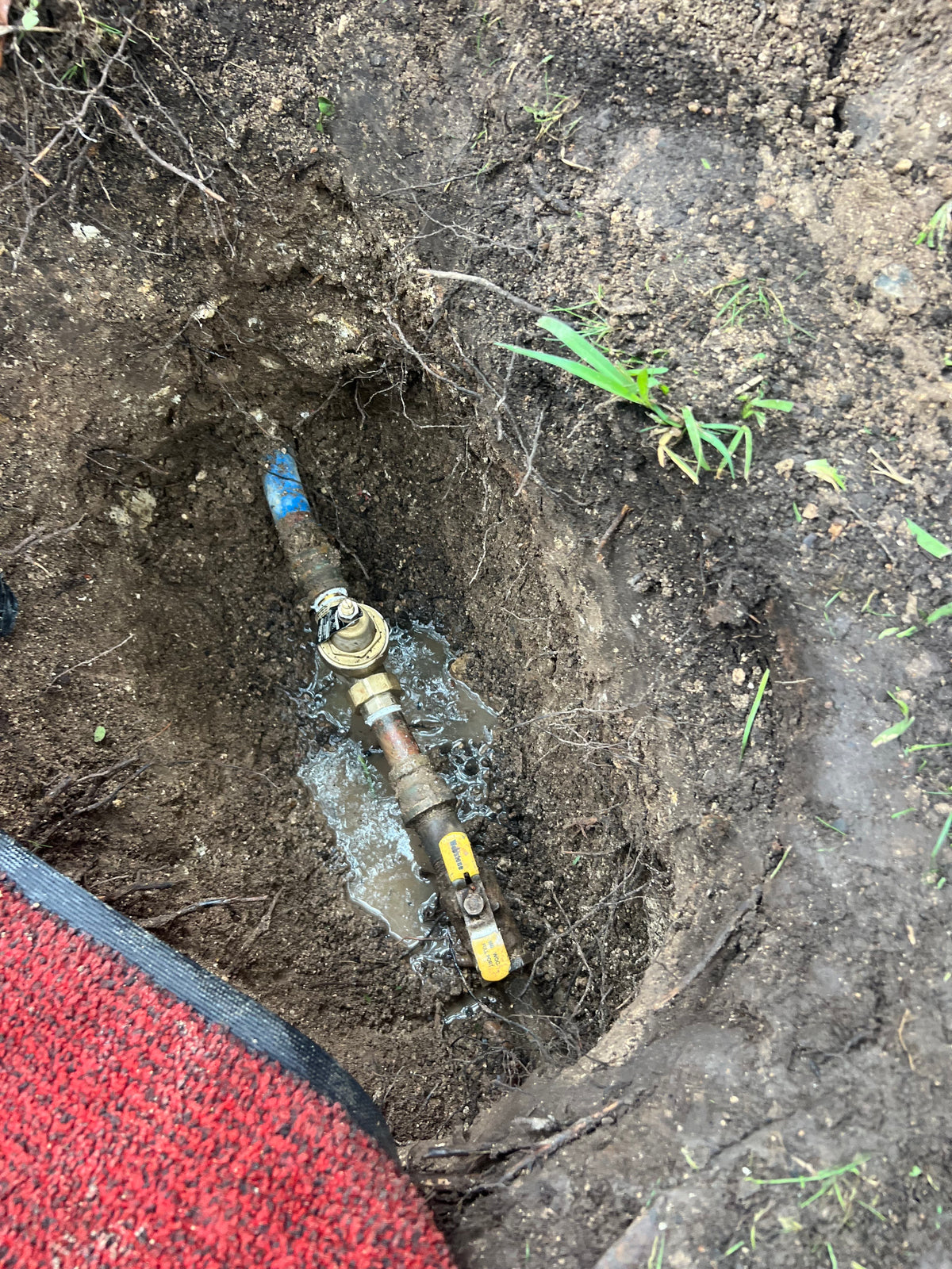 plumbing Pipe fitting on the ground with soil and grass around. Austin tx plumbing